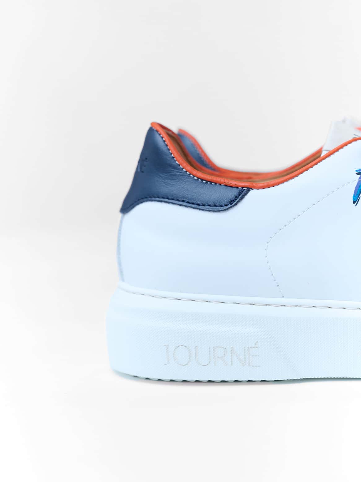Fersenansicht des Petra Sneakers – Lederdetail in Marineblau mit Prägung