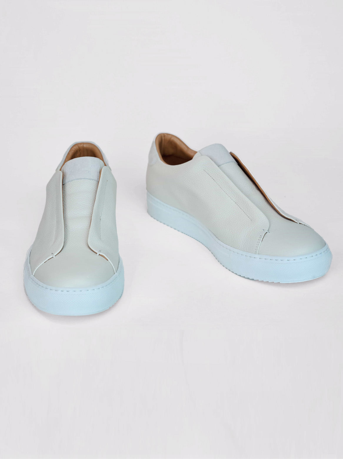 Sneaker in Offwhite frontal auf weißem Hintergrund