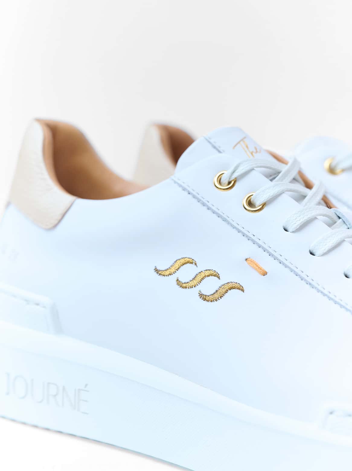 Detailansicht des Adriana Sneakers – goldene Wellenstickerei und feine Handnaht in Großaufnahme