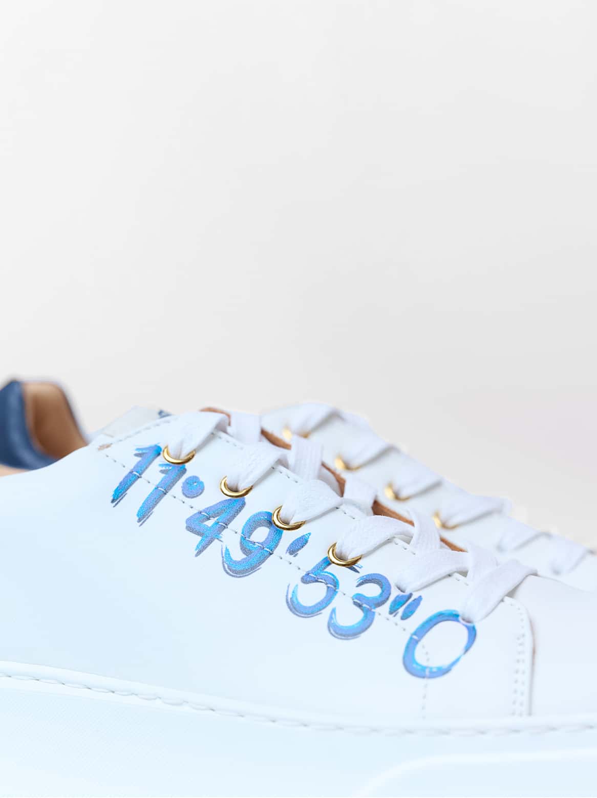 Paulo Sneaker Weiß – Nahaufnahme des Koordinaten-Schriftzugs