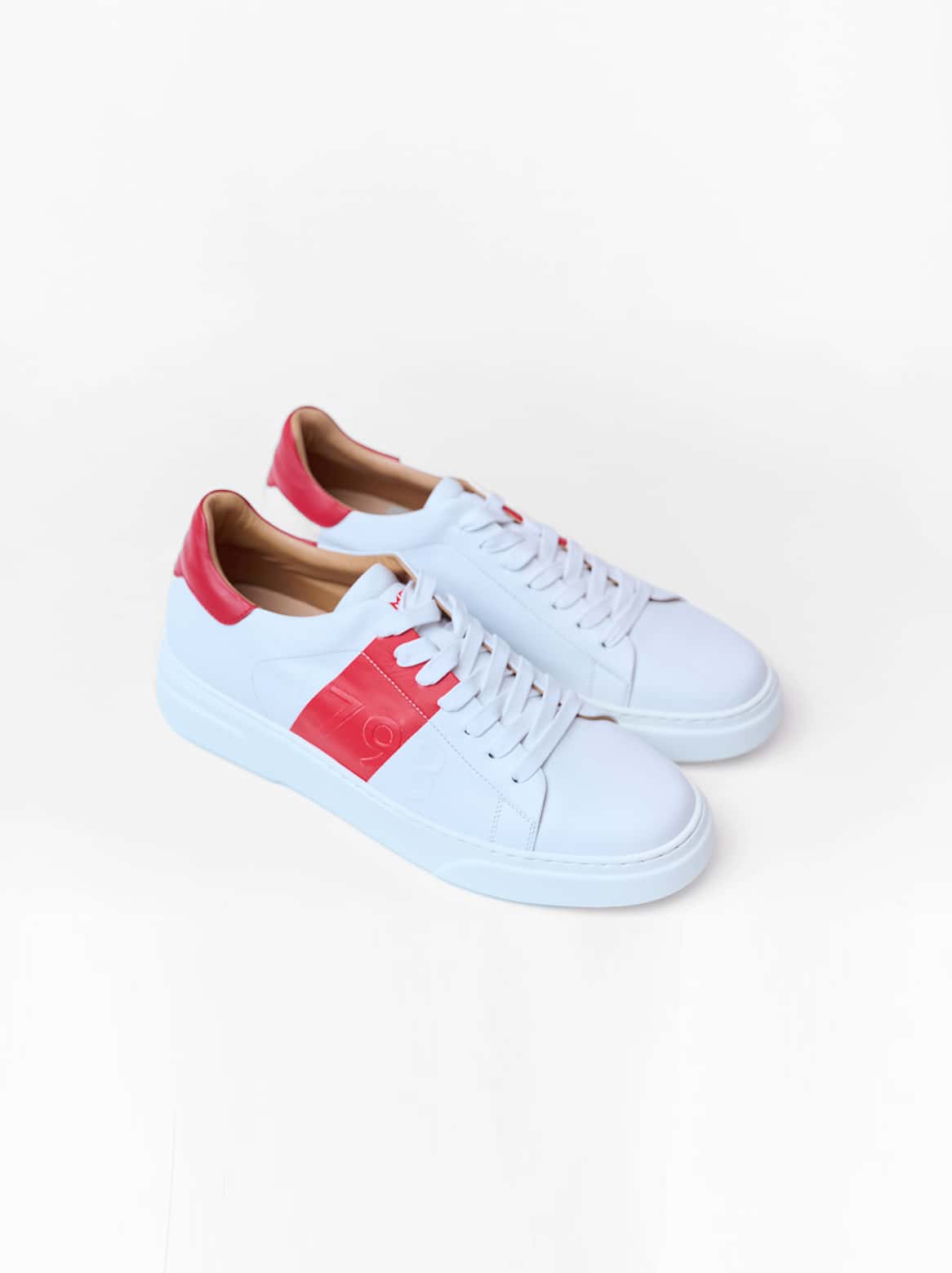 Seitliche Gesamtansicht – Weißer Sneaker mit rotem Lederelement